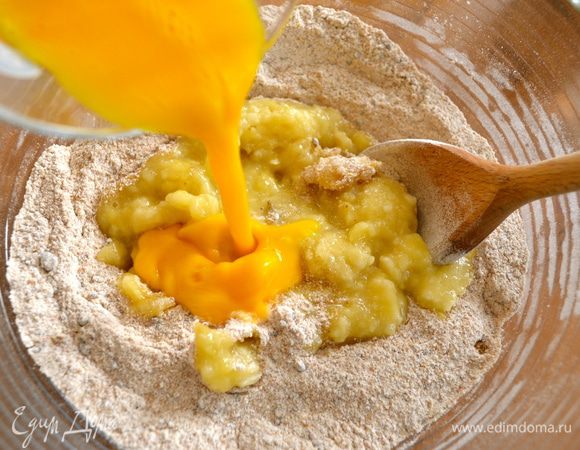 В крупной миске смешать муку, разрыхлитель, пищевую соду, щепотку соли и сахар. Создать углубление в смеси этих сухих ингредиентов и добавить раздавленные бананы, слегка взбитое в стакане яйцо,... 