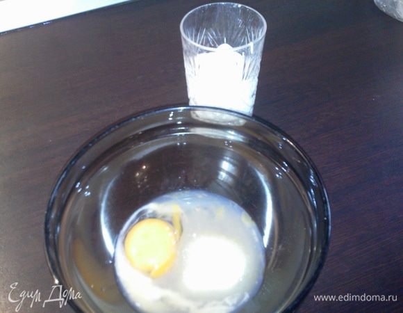 В отдельной миске взбить яйцо с сахаром, сметаной и погашенной содой