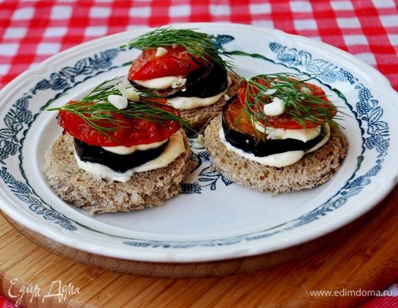 Баклажан вымть,вытереть на сухо,порезать на кружочки(на 6 кружков)

Помидоры вымыть,вытереть на сухо,нарезать на кружочки.

В сковороде разогрть раст.масло,обжарить с двух сторон кружочки балажан,затем кружочки помидор,посолить их по вкусу,выложить обжаренные овощи на салфетку,что бы впитали лишнее масло.

Чеснок очистить и мелко порубить.

Из кусков хлеба вырезать стаканчиком кружочки,намазать хлеб творожным сыром,сверху положить кружок баклажана,посыпать измельчённым чеснокоом,снова творожный сыр(в творожный сыр по желанию можно добавить сливки), и кружок помидора,украсить веточкой укропа.

Приятного аппетита!