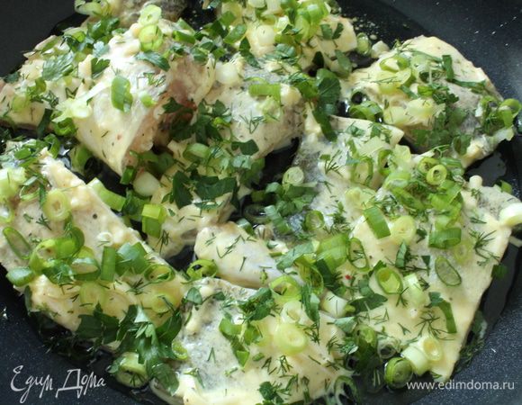 На дно сковороды налить растительное масло, выкладываем куски рыбы, посыпаем нарезанной зеленью, добавляем несколько кусочков лаврового листика.