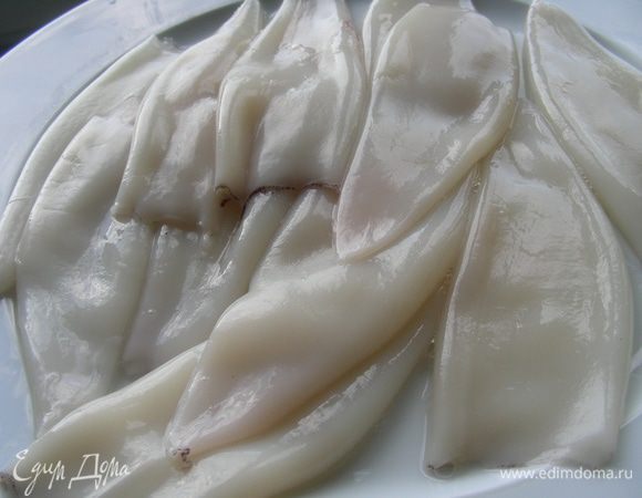 Кальмары очистите. Снимите верхнюю прозрачную пленку, для этого кальмары можно на 1 минуту опустить в горячую воду.