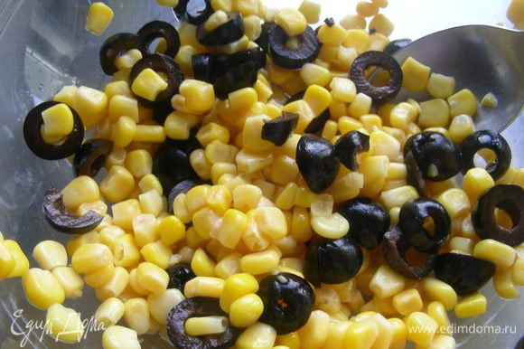 Оливки нарежьте колечками и выложите в салатницу. Добавьте кукурузу, рис и грибы.