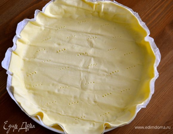 Слоеное тесто выложить в форму (диаметром 26-28 см) и наколоть вилкой.