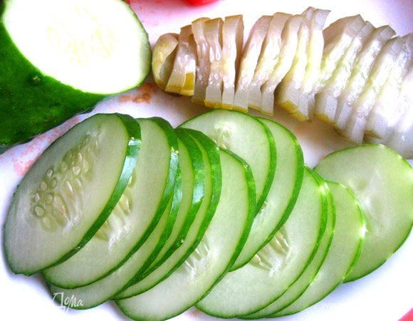 Свежий и солёный огурец разрезать на дольки.