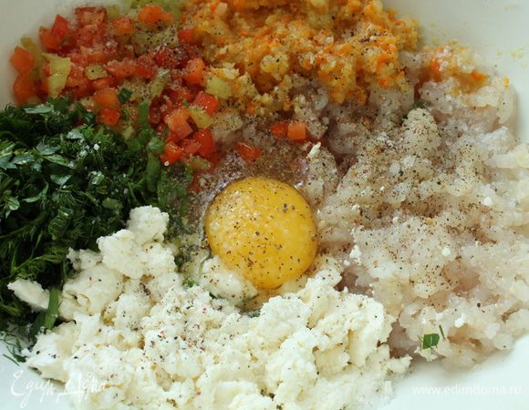 Приготовим фарш: репчатый лук нарезать полукольцами, морковь натереть на крупной терке и слегка обжарить на растительном масле, остудить. У болгарского перца удалить семена, нарезать мелким кубиком. Рыбное филе пропустить через мясорубку вместе с остывшим луком и морковью, добавить яйцо, творог, зелень, болгарский перец, посолить, поперчить,