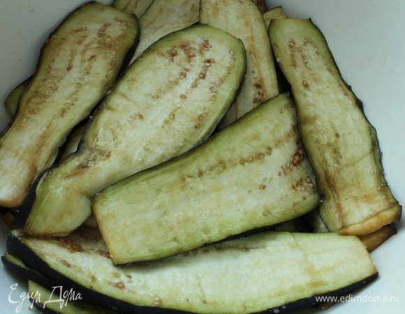 Баклажаны помыть, нарезать вдоль тонкими пластинками, посолить, перемешать, накрыть крышкой и оставить на 30 минут