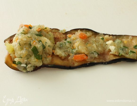 Баклажаны отжать от выделившегося сока, разровнять. На широкую сторону баклажана выкладываем горкой рыбный фарш, а также наносим тоненький слой фарша по поверхности всего баклажанового пластика. Этот слой фарша потом не даст рулетику развернуться во время тушения.