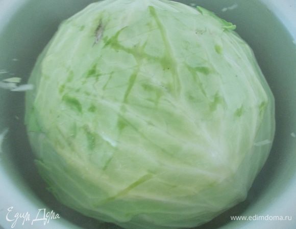 Капусту положите в глубокую кастрюлю и залейте кипятком, поставьте на средний огонь. У кочана будут отделяться верхние листочки, которые легко снимаются вилкой.