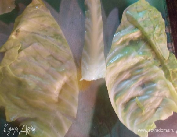 Подготовьте листья капусты для фарширования. Для этого большие листья разрежьте пополам, удалите толстое основание.