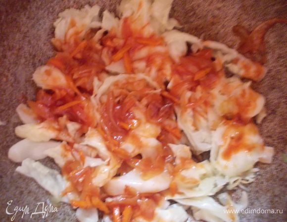 Возьмите кастрюлю с толстым дном. Нарежьте туда остатки капусты и полейте подливой. Выложите слой голубцов.