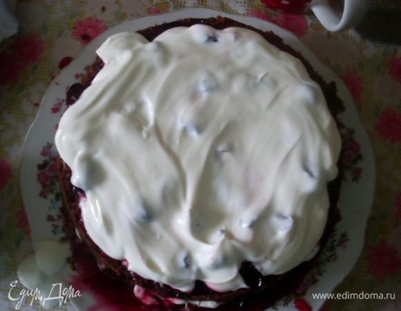 Поверх вишен выложить 1/3 сметаны. Со вторым коржом поступить также. Закрыть верхним коржом.