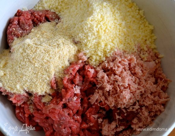 В глубокой миске смешать мясной фарш, измельченную колбасу, мелко тертый сыр и панировочные сухари.