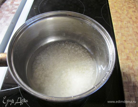 Рис надо промыть 4-5 раз, чтобы избавить от любых посторонних примесей. Рис заливаем водой и доводим до кипения. Варим 5 минут, убавляем огонь,  накрываем крышкой и варим еще 10 минут. Пар не должен выходить из кастрюли. Затем снимаем с огня и держим еще 15 минут. Только после этого можно снять с риса крышку. Если к готовому рису добавить соевый соус, он   приобретет коричневый цвет. Соль в этом случае добавлять не надо.