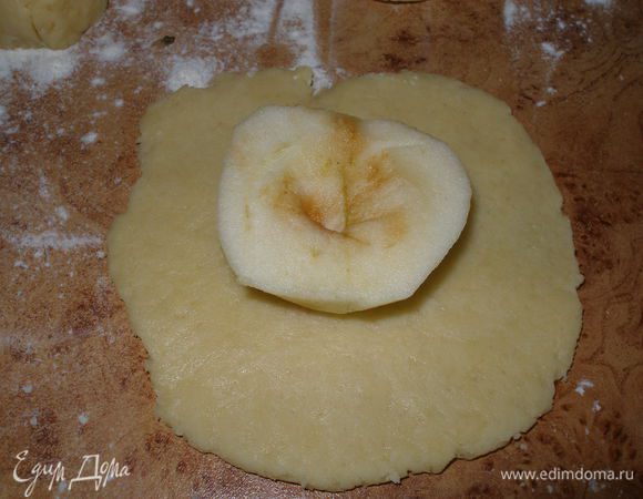 Разделить тесто,у меня из этого количества ингредиентов выходит 9-10 печенек. Каждый шарик раскатать в лепешку и на нее положить половинку яблока,срезом вверх.
