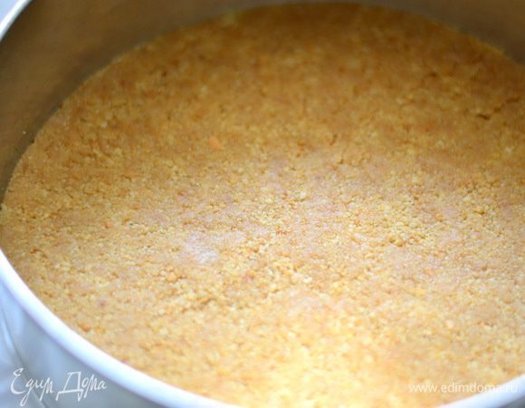 Застелите форму пергаментом, выложите крошку и разровняйте. Выпекать в предварительно разогретой духовке при температуре 150°C в течение 20 минут.