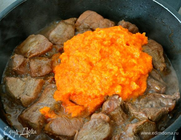 Выложить к мясу измельченные овощи, как следует перемешать, уменьшить огонь и тушить пока мясо не станет мягким, а соус не загустеет. 