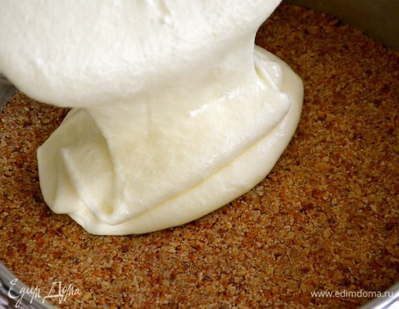 Добавить взбитые белки в крем и осторожными движениями перемешать. Выложить сырную массу на подготовленный корж.