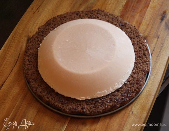 Приступим к сборке. В форму с разъемными боками выложим наш бисквит,при необходимости подрежьте. Бока лучше снять,чтобы была возможность поправить начинку. На бисквит выкладываем пару ложек нашего малинового конфитюра и размазывааем его по диаметру начинки. Сверху кладем наш подмороженный крем. Чтобы достать его из мисочки,нужно на минуту поставить в тарелку с горячей водой. У меня были большие волнения,как я его достану и не деформирую ли его,все прошло гладко).