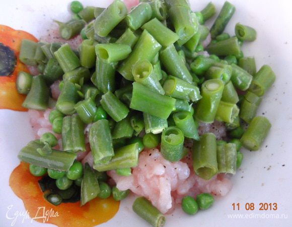 Из второй части филе грудки сделать фарш на мясорубке, добавить соль, черный перец, приправы по вкусу, измельченный чеснок. Все хорошо перемешать и добавить предварительно размороженные фасоль и зеленый горошек, еще раз перемешать и отставить в сторону.