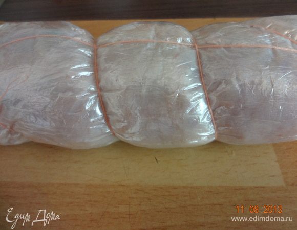 Свернуть плотный рулет, обернуть пленкой, загибая внутрь края, связать рулет кулинарным шпагатом или нитью. В большой кастрюле вскипятить воду, можно добавить пару лавровых листиков, осторожно опустить рулет в кипящую воду и варить 30 минут. Затем вынуть и положить под пресс до полного остывания. Я делаю так: сливаю воду из кастрюли, на дно укладываю галантин, накрываю подходящим блюдом, а сверху ставлю груз (например 500-граммовую банку с вареньем), оставляю на столе пока не остынет, а потом перекладываю в холодильник еще часов на 6-8. Тогда готовый галантин  получается вкуснее и сочнее.