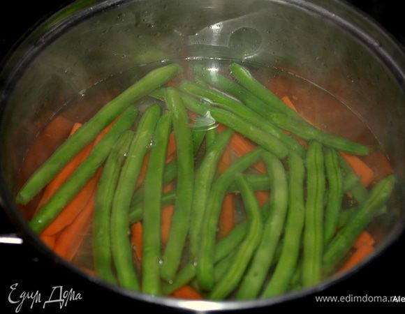 Зеленую фасоль и морковь положить в кастрюлю с горячей водой, чтоб вода лишь накрыла овощи. Варим до мягкого состояния фасоль и морковь,примерно 5-8 мин. под закрытой крышкой. Затем воду слить.