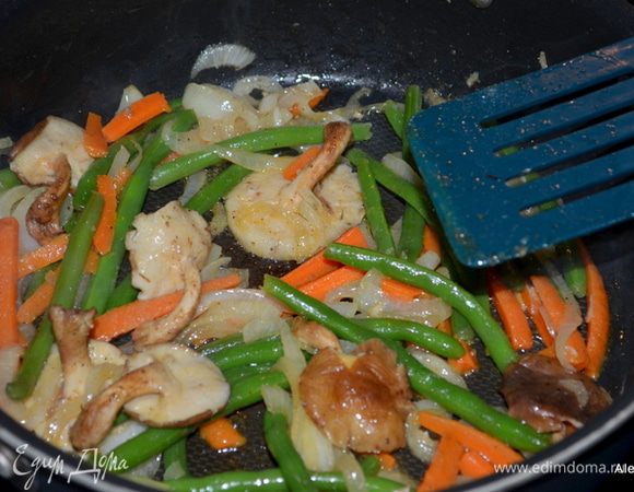 Затем добавить зеленую фасоль и морковь, посолить и поперчить специями. Закрыть крышкой и готовить 5 мин. все вместе.