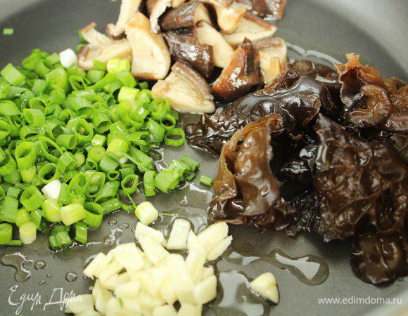 Чеснок очистить и измельчить. Зеленый лук вымыть, обсушить и нарезать тонкими колечками. Разогреть в сковороде 1 ст. л. острого масла, обжарить  грибы, 4 мин. Добавить чеснок, зеленый лук, лимонный сок, соевый соус и сахар. Готовить, помешивая, 3 мин. Накрыть и снять с огня.