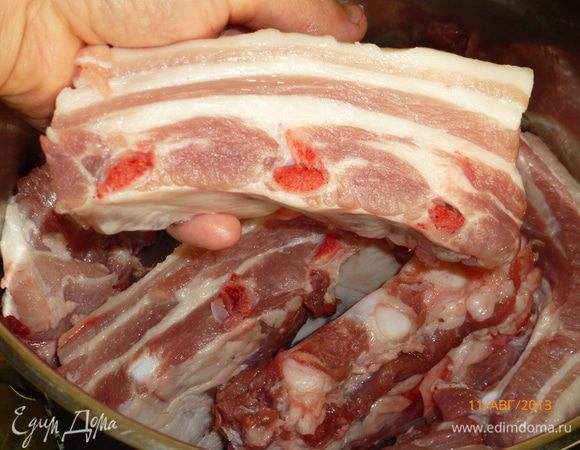 Разрезаем ребрышки на куски по 3-4 ребра и выкладываем их в кастрюлю с толстым дном.