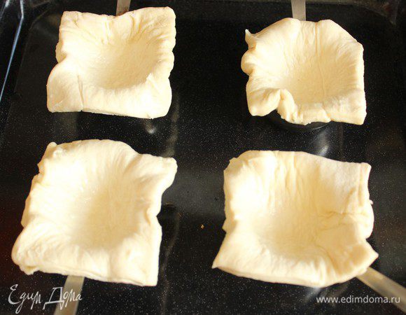 Я использовала готовое слоеное тесто... Разморозить, нарезать на квадраты и выложить тесто в смазанные маслом низкие формочки. За неимением таковых я использую кокотницы))) Поставить в разогретую духовку и запечь в течение 5 минут. Даже не запечь, а слегка подсушить...