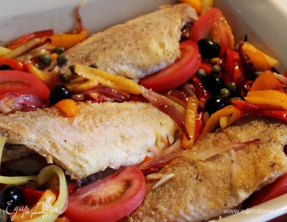 На рыбу выложить тушёные овощи, дольки помидоров, маслины и каперсы. Запекать рыбу при 180*С около 8-10 минут.