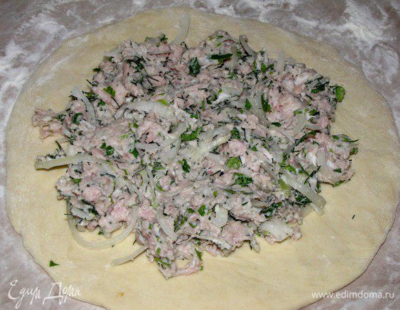 Тесто раскатать на столе одной большой лепешкой, или разделить на две части и раскатать две лепешки поменьше. Толщина теста должна быть не менее 8 мм. Выложить в центр начинку, разровнять.