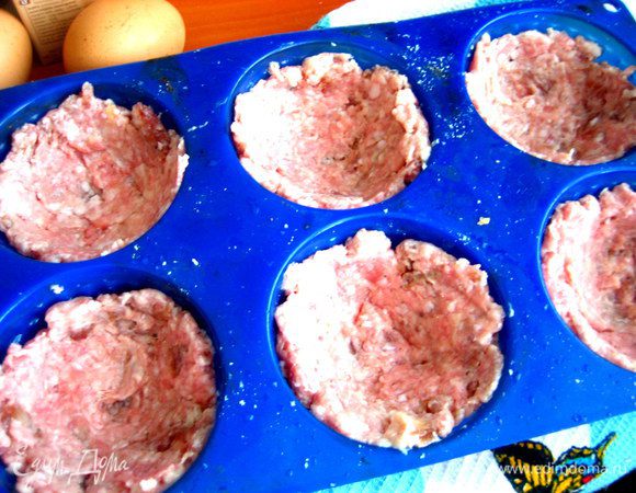 Разминаем по дну каждой ячейки котлетную массу...Раз у меня ушло 300 г на все,значит,на каждую-50 г фарша.
