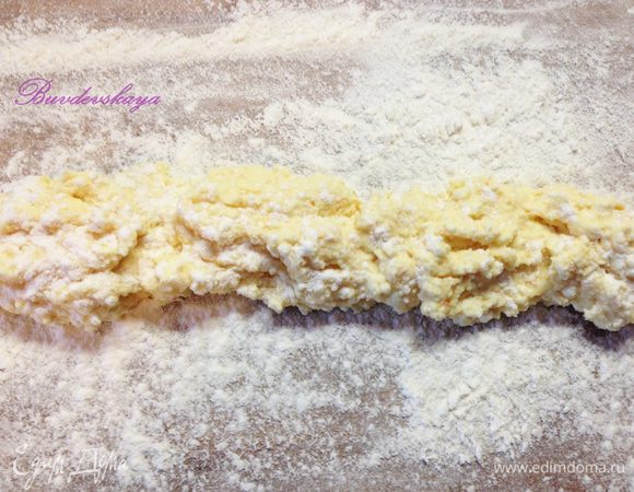 4.	Рабочую поверхность присыпать мукой. Выложить творожную смесь полоской. Сверху немного припорошить мукой. 