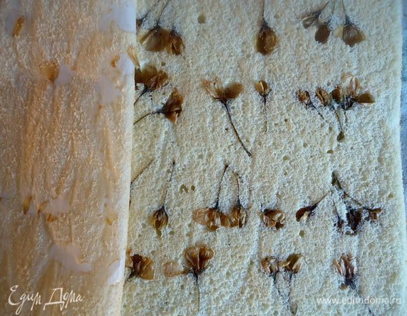 Готовый бисквит перевернуть на полотенце, бумагой вверх.
Очень аккуратно снять бумагу, стараясь не повредить бутоны.
