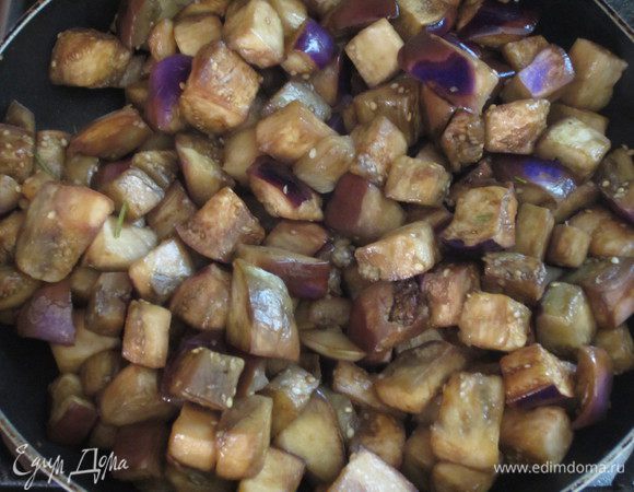 Чеснок вынуть, добавить баклажаны и готовить на среднем огне 15 минут .