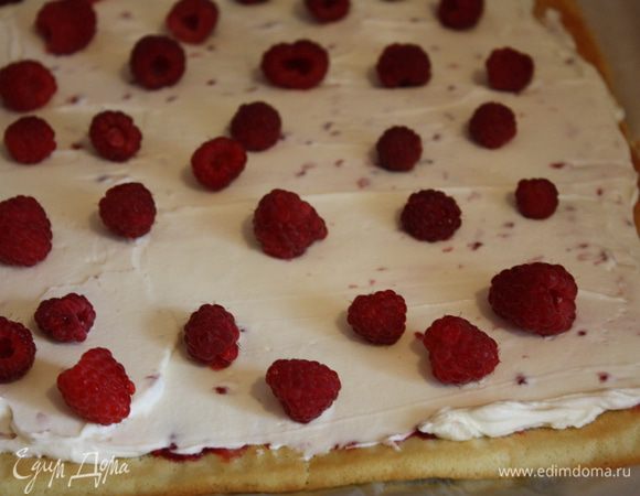 С остывшего бисквита снять бумагу, смазать его джемом. Сверху выложить крем и малину. Немного крема оставить для смазывания поверхности.