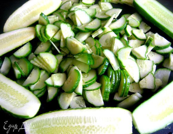 Нарезаем сначала вдоль пополам, а затем на тонкие полукольца. Если огурцы-великаны, то сначала на четвертинки вдоль...