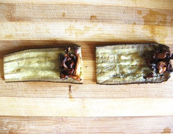 Пластинки баклажанов разрезать на две равные части поперек.
На один край каждой пластинки баклажанов выложить немного обжаренных лисичек