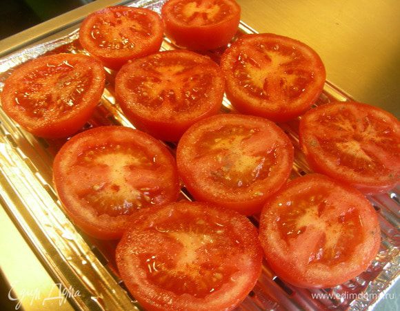 Помидоры разрезаем напополам и выкладываем в смазанную маслом форму для запекания. Посыпаем солью, перцем, паприкой. 
