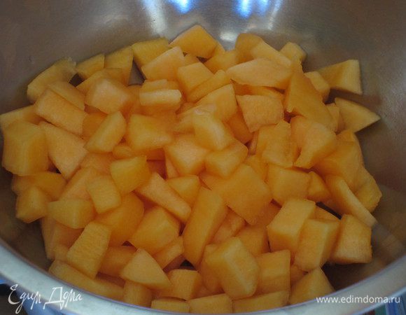 Дыню вымыть, вытереть, разрезать пополам, удалить семечки и прожилки. Очистить и нарезать мякоть кубиками.