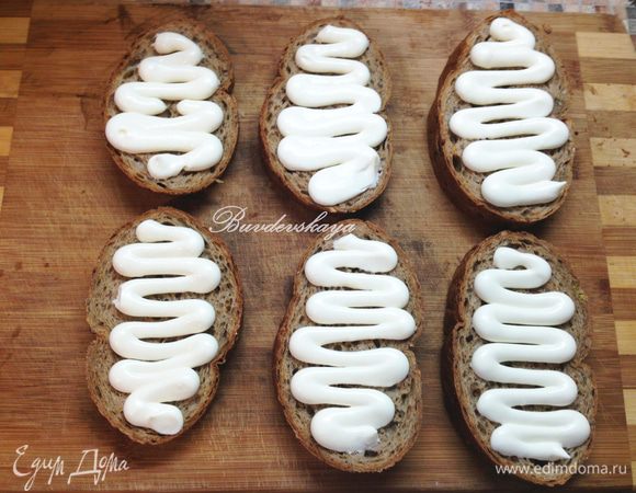 Нарезать хлеб на кусочки средней толщины. Намазать хлеб майонезом.