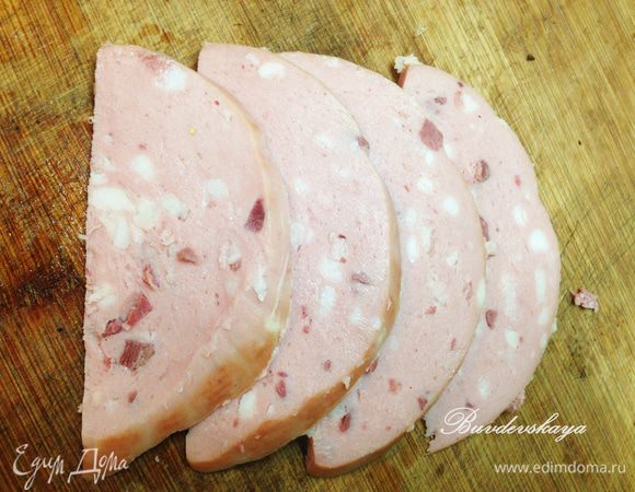 Колбасу нарезать ломтиками и выложить по 2 штучки на каждый бутерброд.