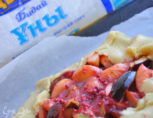 Раскатываем наше охлажденное тесто на противне с пергаментом в пласт. Посыпаем манкой или миндалем, выкладываем начинку и загибаем края, смазываем желтком и посыпаем сахаром. 