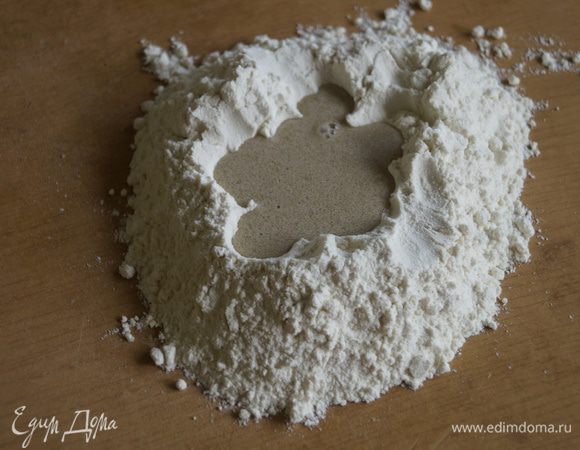 На столе сделать из муки горку с углублением. Влить туда дрожжи разведенные водой. В отдельной чашке смешать соль, сахар и молоко и тоже влить в углубление. Смешать с половиной муки.