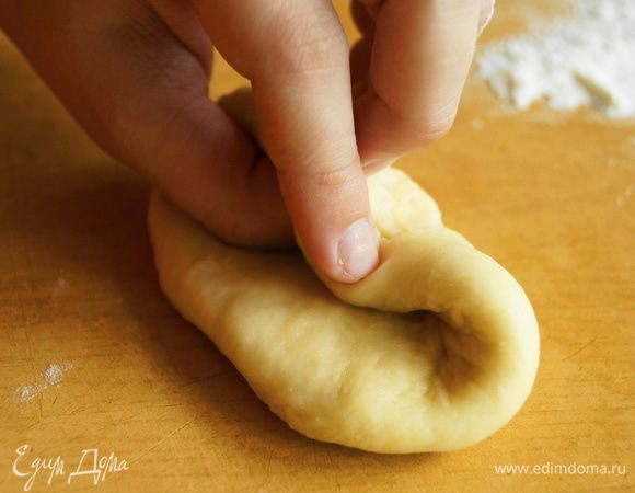 Пальцами левой руки нужно взяться за край теста, немного выше середины. Большой палец, подвернуть вниз и на него заверните тесто. Пальцами правой руки прижать этот кончик, который соприкоснулся с основным тестом.