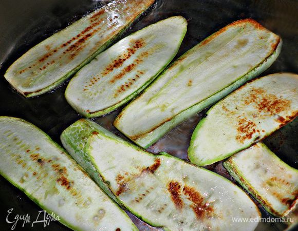 Обжарить на растительном масле кабачки. Желательно использовать сковороду, на которой можно обжаривать овощи с минимальным количеством жира, а в идеале - сковороду-гриль.