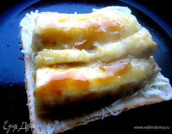 Аккуратно на лопатке переносим обе половинки банана и поливаем сверху мёдом, в котором они жарились, пока не застыл.