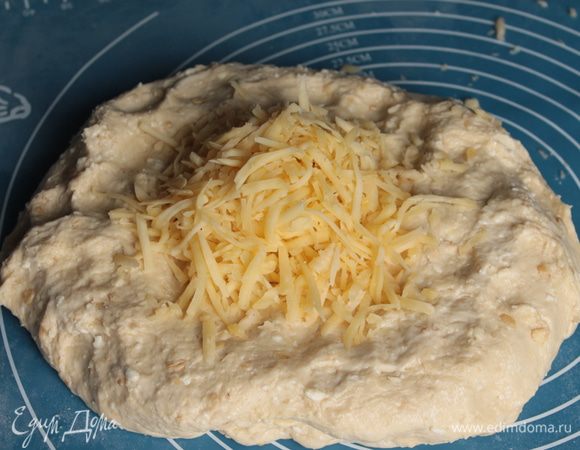 Через час тесто обмять и добавить натертый сыр.