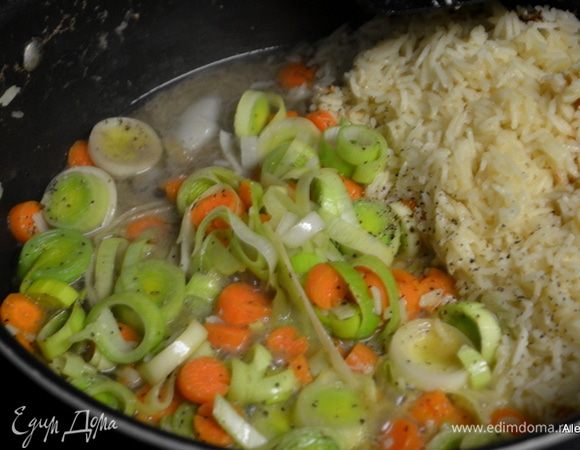Добавить к готовому рису 2 ч.л оливковое масло, порезанный лук порей и морковь колечками. Соль и перец по вкусу. И тушим примерно 7 мин.помешиваем. Если у вас свежий горошек добавим к массе, если замороженный добавим в суп перед подачей на стол.
Добавим бульон, куриные кусочки, сбавим огонь и закроем крышкой.