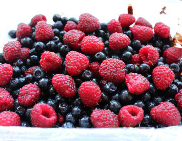 Вынуть форму из холодильника. Уложить сверху ягоды в произвольном порядке.